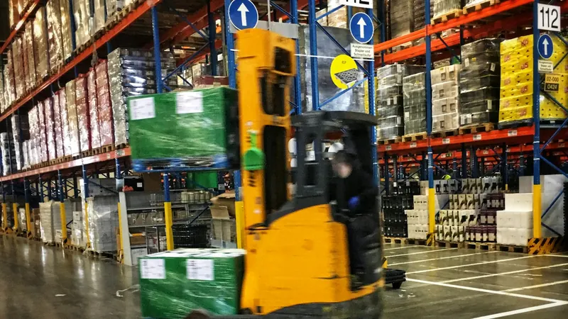 Forklift moving pallets down a warehouse aisle